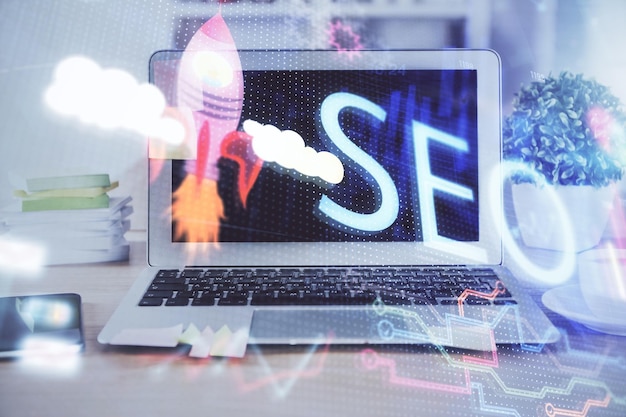 Uma imagem de múltiplas exposições mostrando uma mesa com um notebook, sobreposta com uma ilustração em holograma de conceitos de SEO relacionados à otimização de buscas.
