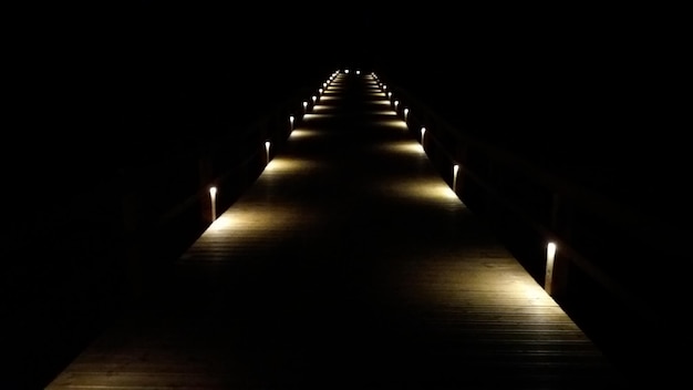 Um corredor pouco iluminado com iluminação suave e quente e características arquitetônicas modernas, criando uma atmosfera convidativa.